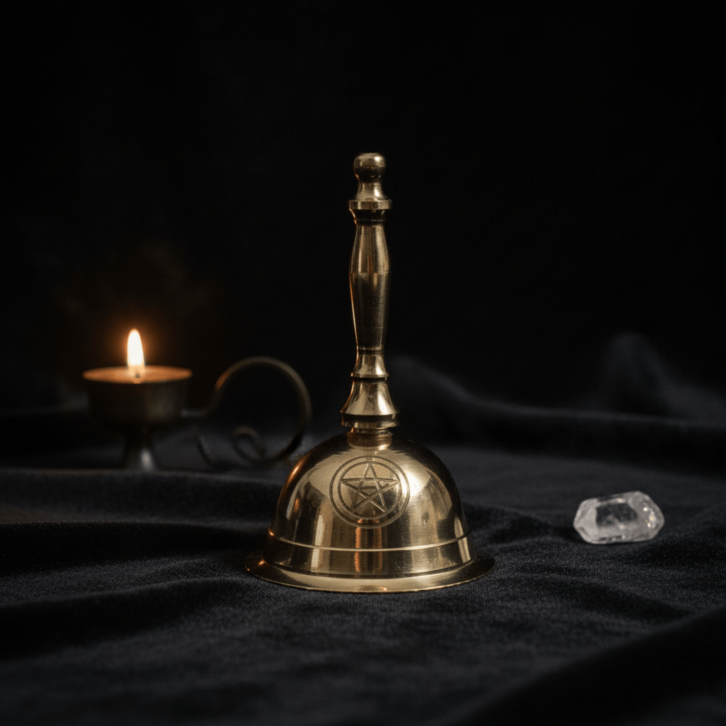 Cloche rituelle en laiton Penta Lune, vue rapprochée avec bougie allumée et cristal clair en décoration