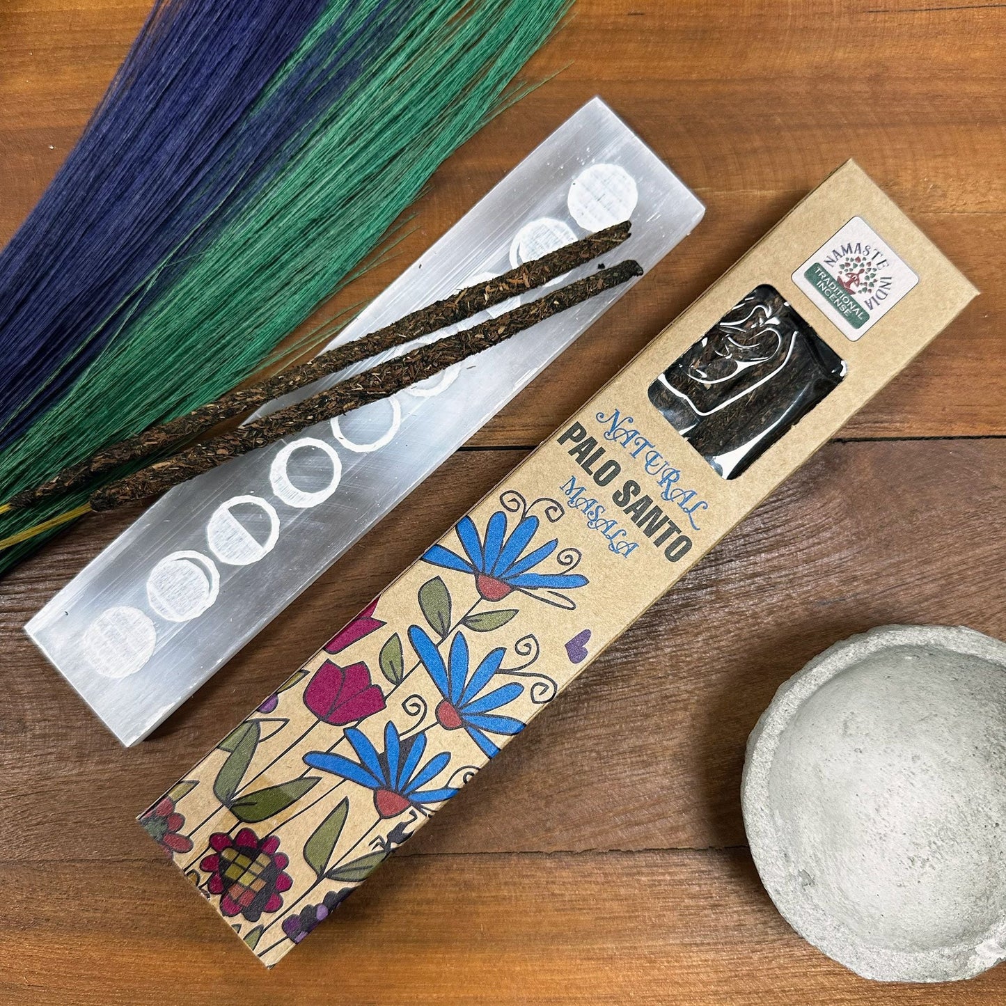 Étui d’encens naturel Palo Santo masala avec bâtons posés près d’un support et décor spirituel.