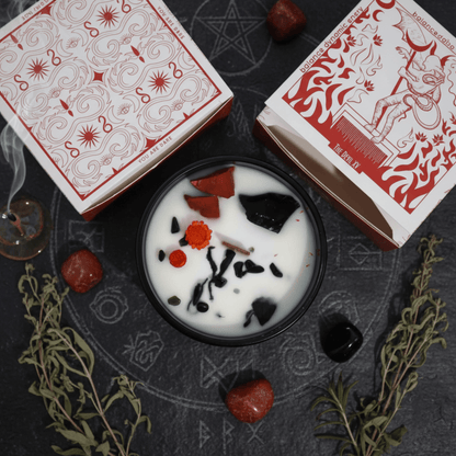 Bougie du Feu ouverte, cristaux rouges et noirs visibles, entourée d’herbes sacrées et symboles ésotériques.