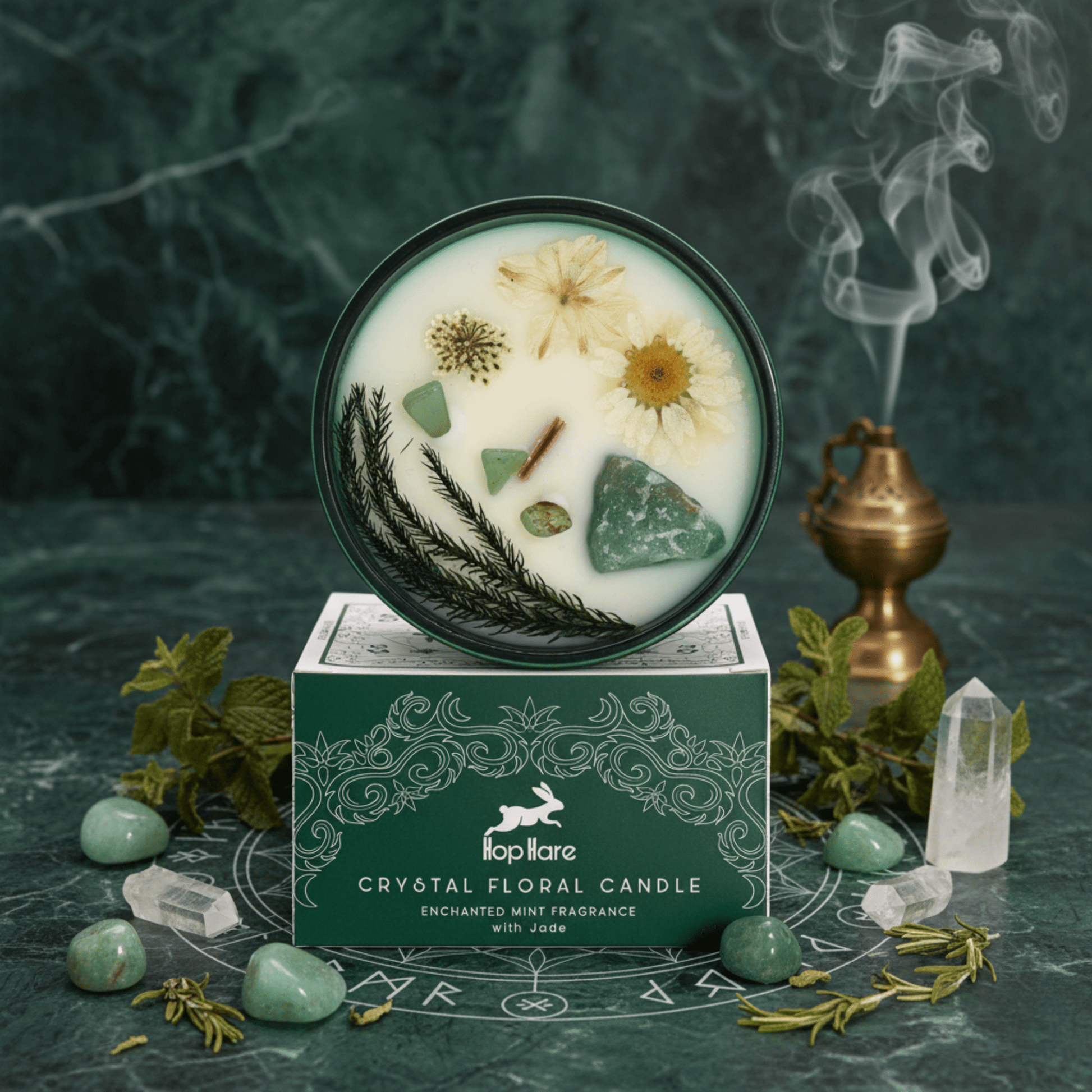Bougie du Magicien Hop Hare avec jade, fleurs séchées et menthe enchantée, posée sur sa boîte verte ésotérique.