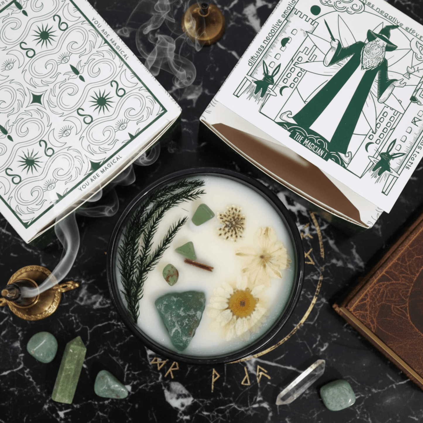 Bougie cristal menthe avec pierres de jade et fleurs, présentée avec son emballage Magician et accessoires mystiques.