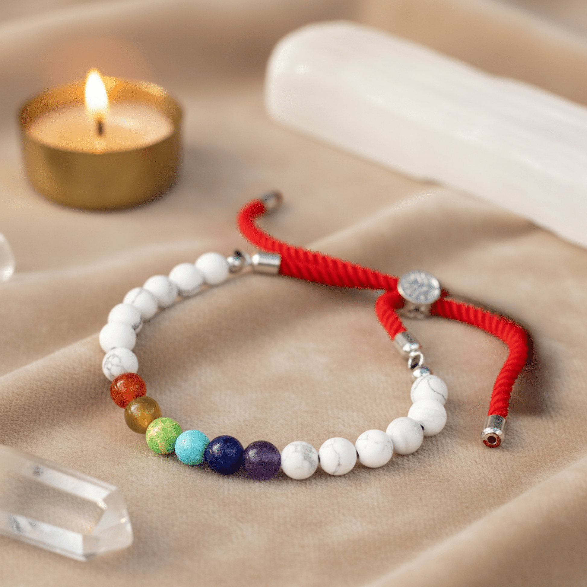 Bracelet de chakras en howlite blanche avec cordon rouge, perles colorées pour alignement et vitalité.