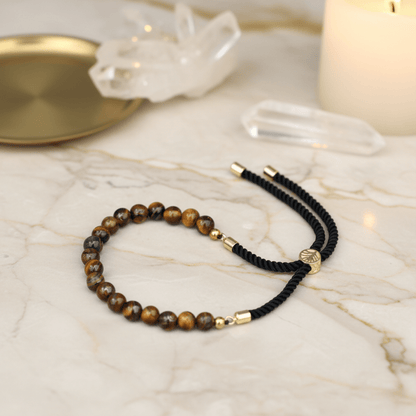 Bracelet œil de tigre unisexe avec cordon noir tressé et fermoir or 18K, bijou d’ancrage et de force intérieure.