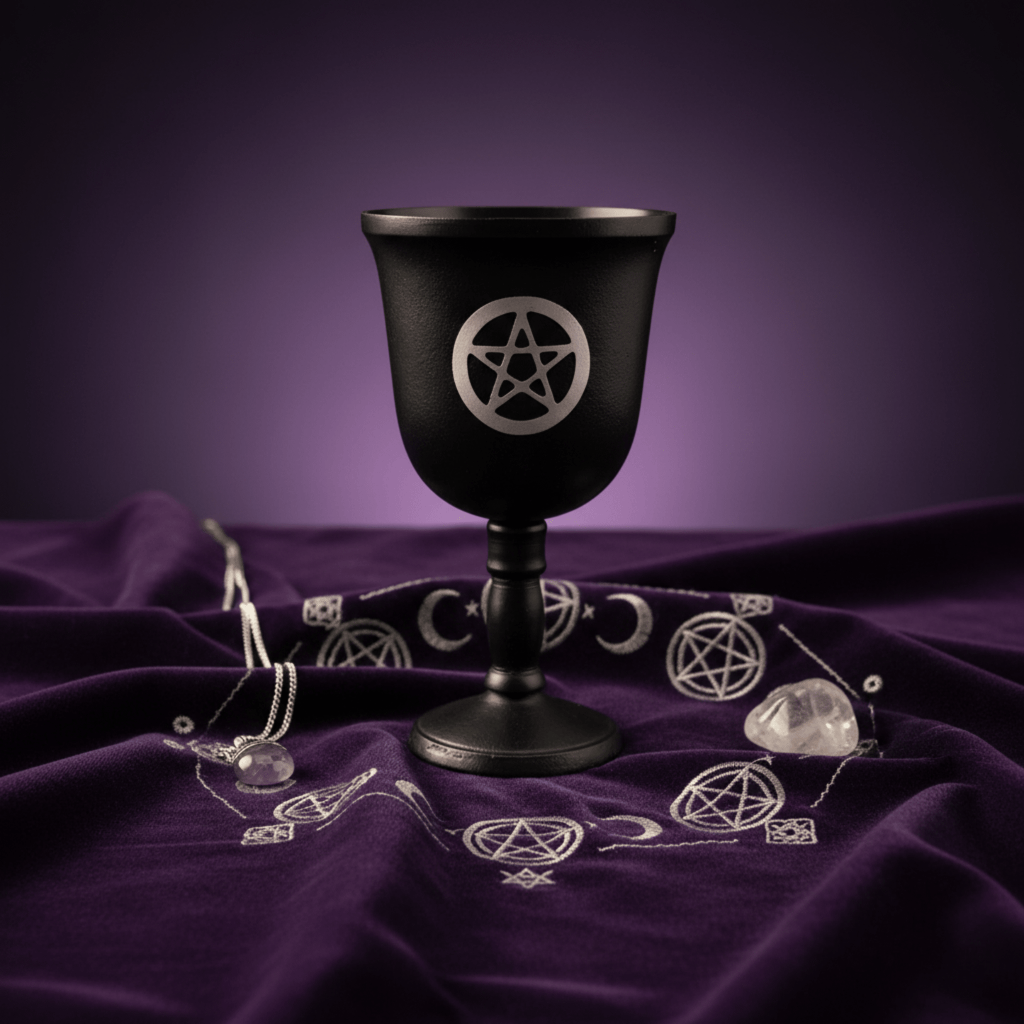 Calice rituel noir avec pentacle, posé sur tissu violet wicca, accessoire d’autel pour sorcellerie et rituels magiques.