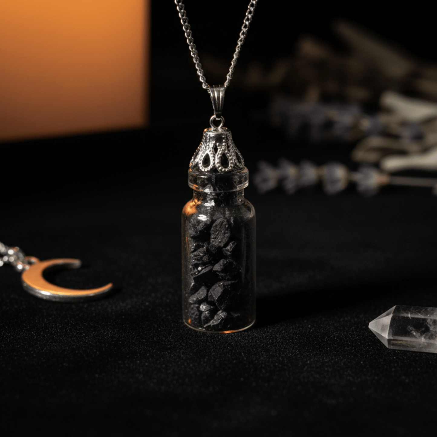 Collier bouteille avec fragments d’onyx noir dans une fiole en verre sur fond sombre.