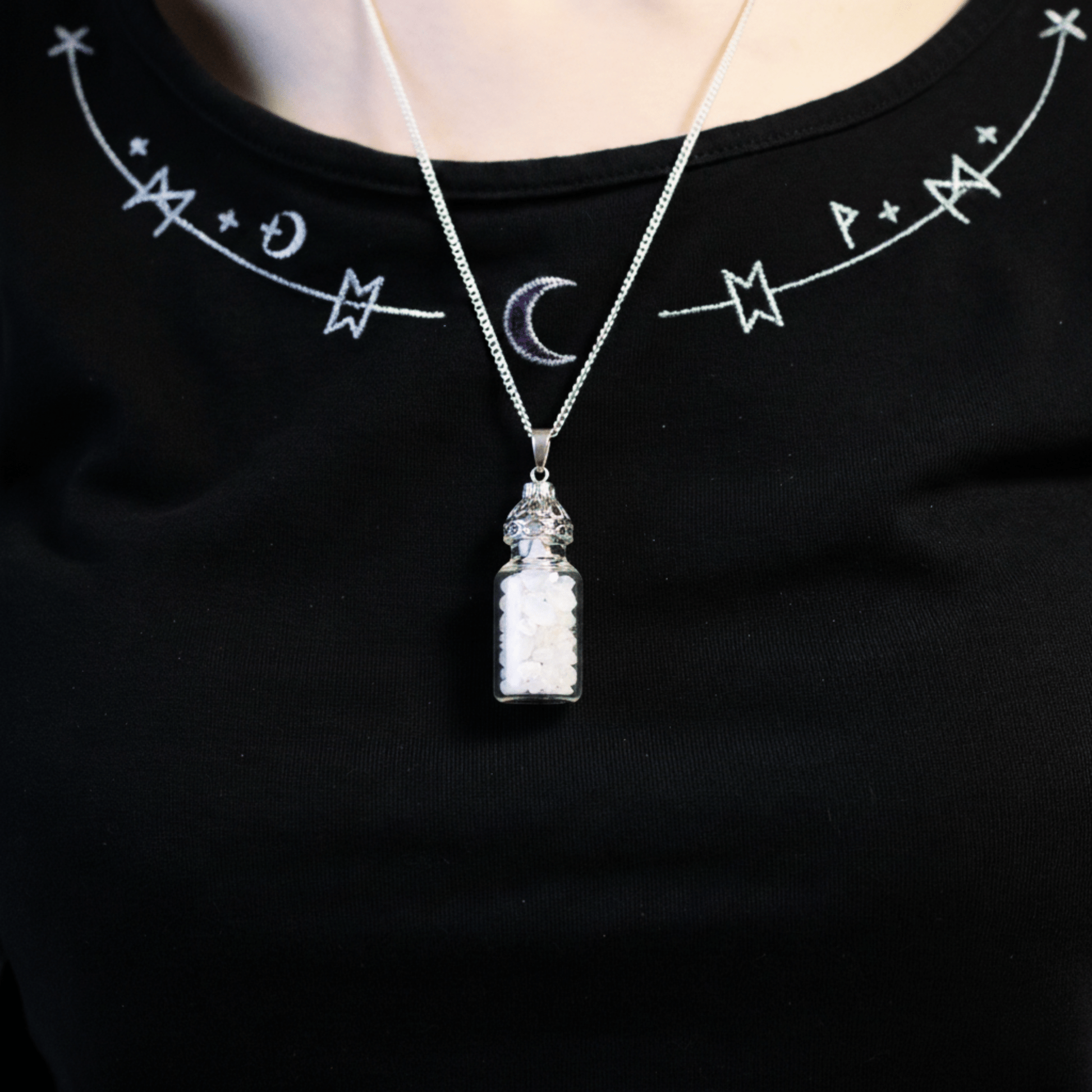 Collier bouteille/fiole opalite porté autour du cou, fiole remplie de gemmes blanches iridescentes.