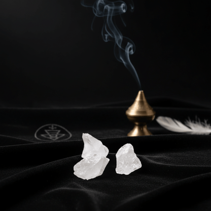Cristaux de roche brut sur tissu noir avec fumée d’encens, pierre de lumière et de clarté spirituelle.