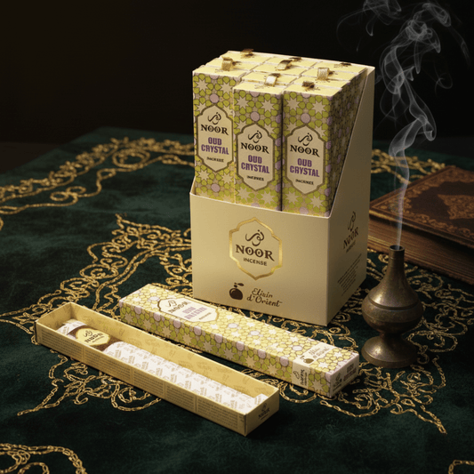 Boîte d’encens Noor Oud Crystal sur tissu oriental vert, fumée d’encens et décor mystique pour rituel parfumé oriental.