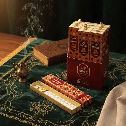 Encens Noor Oud Ruby avec présentoir rouge, fumée parfumée et décor oriental sur tissu brodé vert.