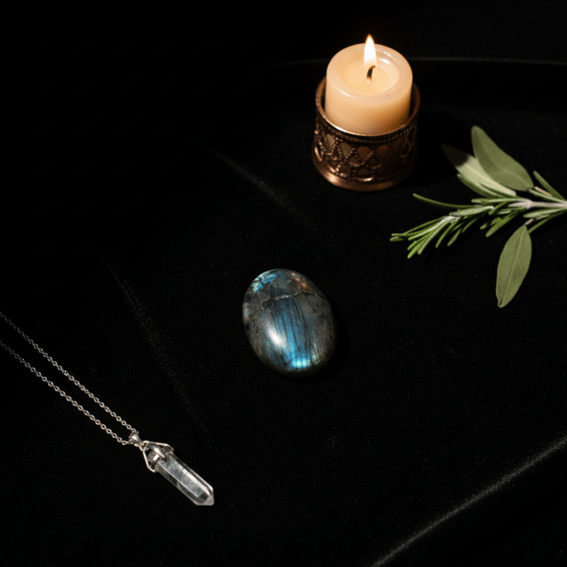 Labradorite polie aux reflets bleus, pierre de protection énergétique avec bougie et branche sacrée.