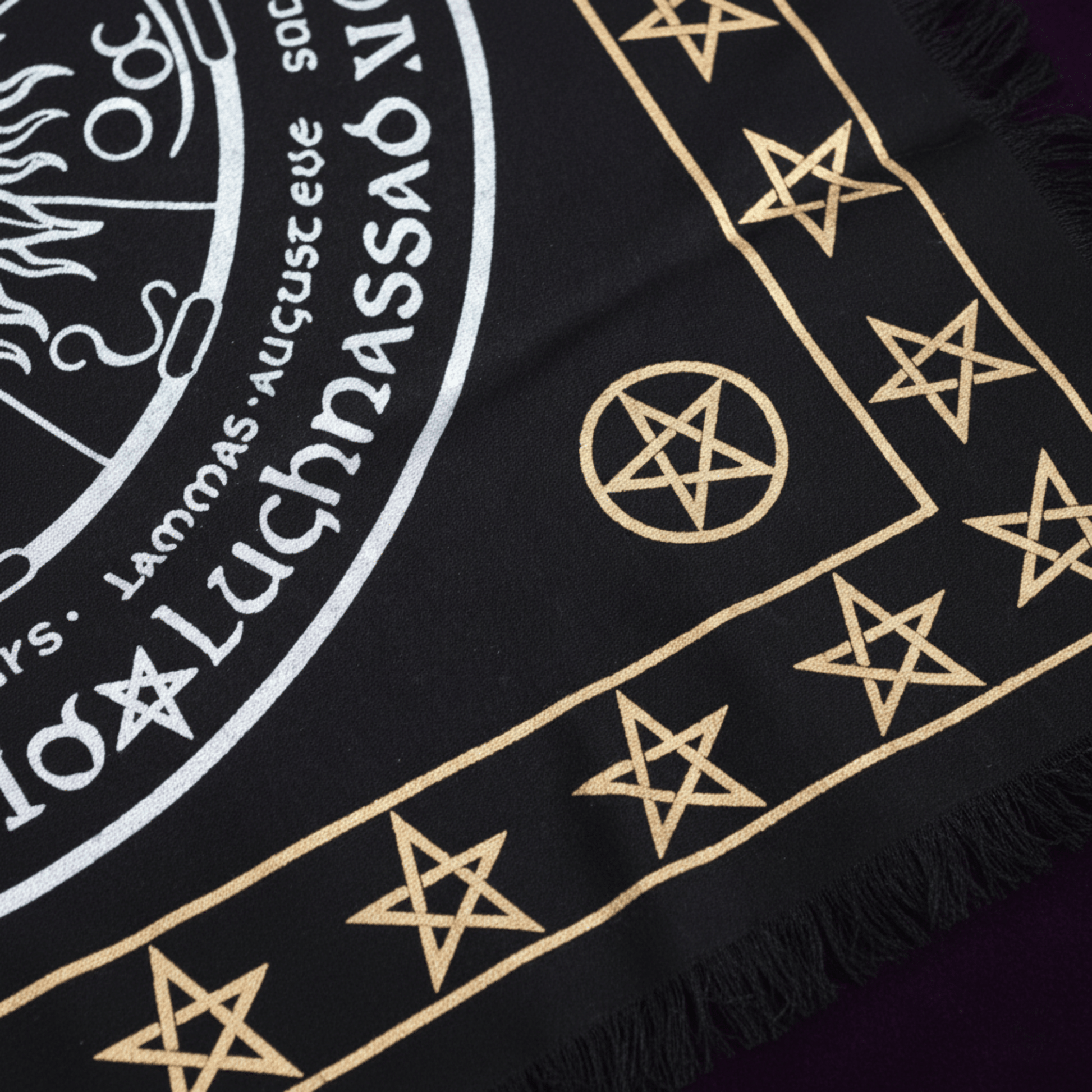 Détail nappe d’autel Wicca frangée avec pentacles dorés et motif spirituel Vie Mort Renaissance.