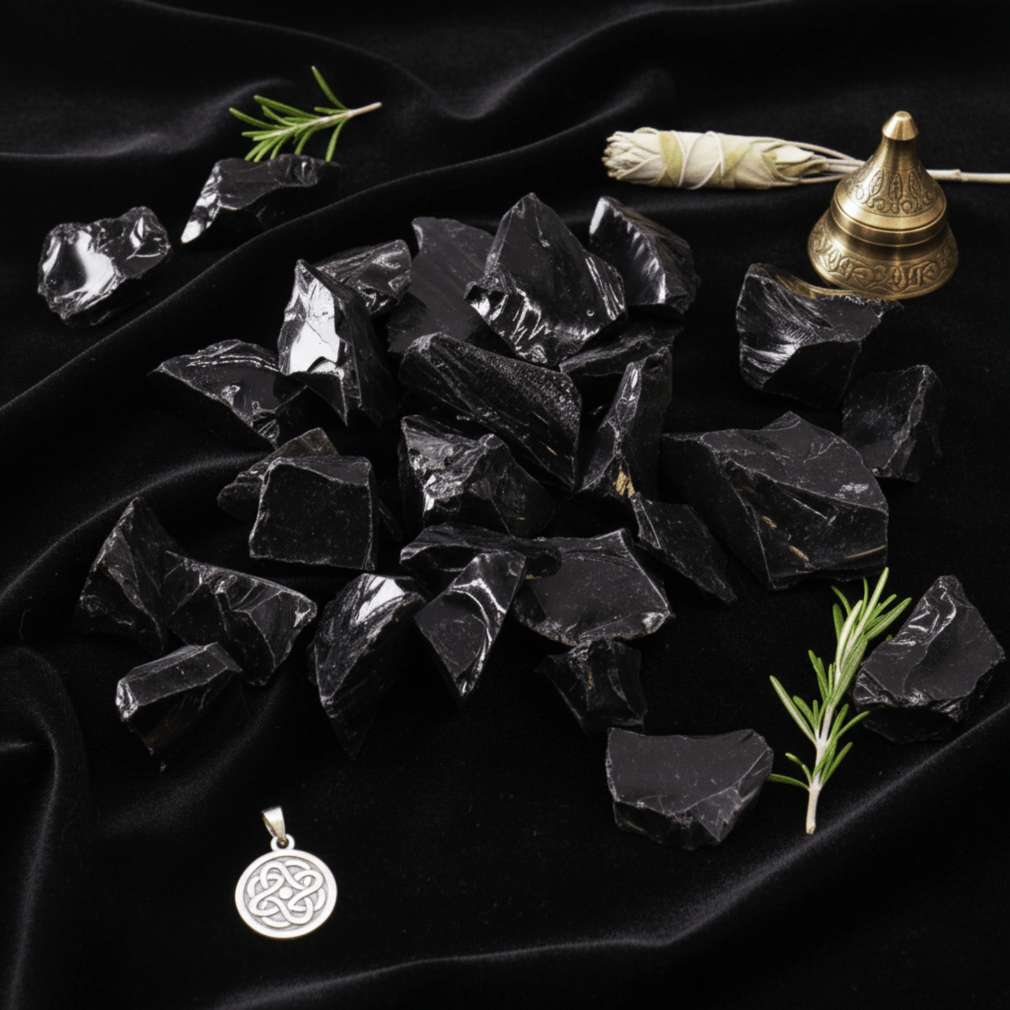 Éclats d’obsidienne noire sur tissu sombre, pierre volcanique de protection et clarté intérieure.