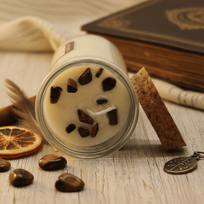 Vue rapprochée d’une bougie rituelle ornée de pierres œil-de-tigre incrustées dans la cire de soja.