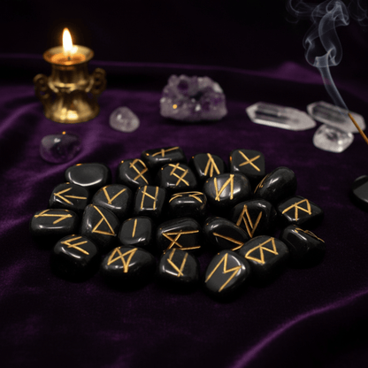 Set de runes en agate noire avec symboles dorés, utilisé pour divination, rituels et guidance spirituelle.