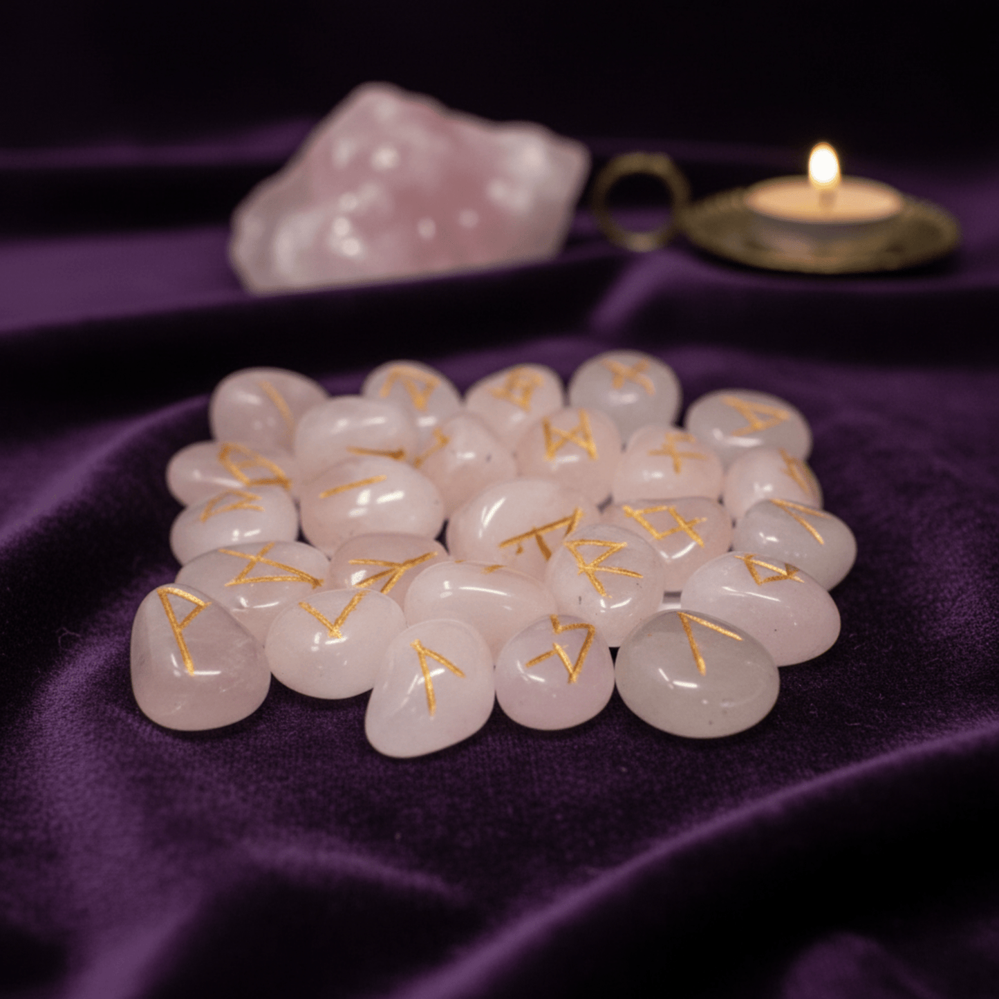Pierres runiques en quartz rose naturel pour divination et amour, runes gravées en doré sur tissu violet.